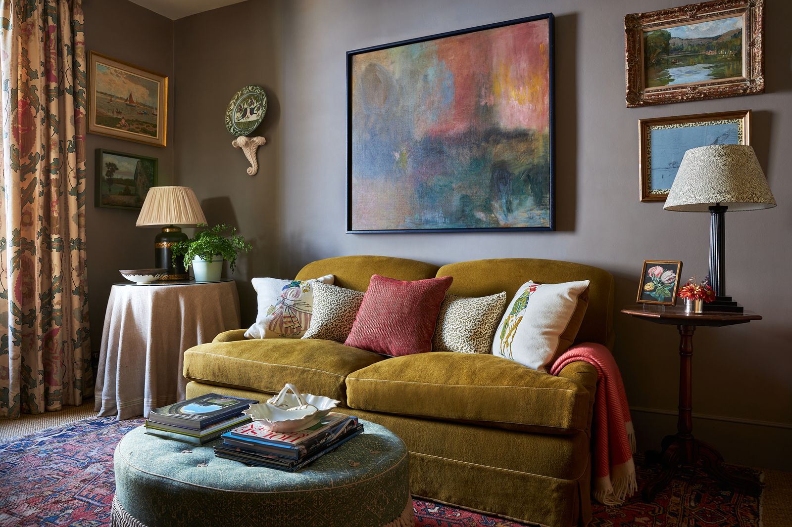 Image may contain Lamp Plant Couch Furniture Home Decor Art Painting Desk Table Rug Architecture and Building
