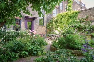 Image may contain Yard Outdoors Nature Vase Plant Pottery Potted Plant Jar Garden Arbour Furniture and Bench
